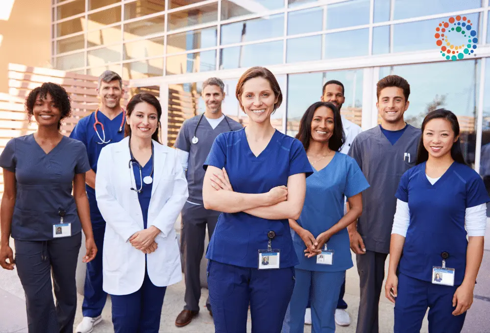 Diverse group of physicians gathers outside a hospital