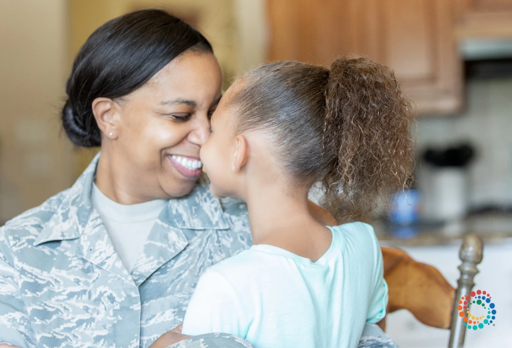 Women in fatigues hugging a young girl